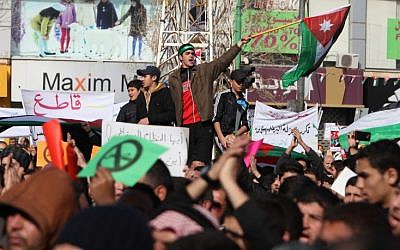 Demonstrators wave the Jordanian flag during a protest by the Muslim Brotherhood movement and other opposition parties against parliamentary elections in Amman, Jordan, in January 2013. (photo credit: AP)