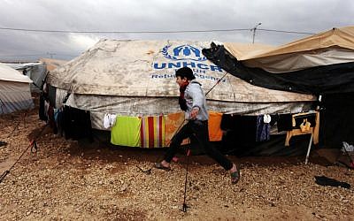 A Syrian refugee boy runs to his family tent at Zaatari Syrian refugee camp, near the Syrian border in Mafraq, Jordan, on January 8, 2013. (AP Photo/Mohammad Hannon)