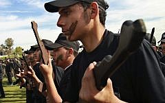 Palestinian students hold rifle-shaped wooden sticks during a graduation ceremony for the first group of schoolchildren's military training organized by the Hamas education ministry in Gaza City, Thursday, January 24 (photo credit: AP/Adel Hana)