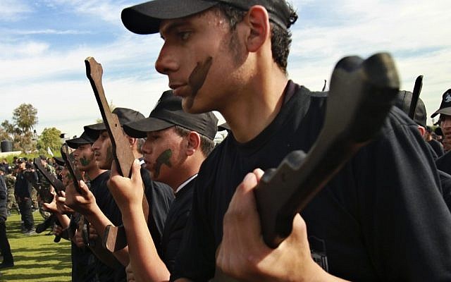 Palestinian students hold rifle-shaped wooden sticks during a graduation ceremony for the first group of schoolchildren's military training organized by the Hamas education ministry in Gaza City, Thursday, January 24 (photo credit: AP/Adel Hana) Palestinian students hold rifle-shaped wooden sticks during a graduation ceremony for the first group of schoolchildren's military training organized by the Hamas education ministry in Gaza City, Thursday, January 24 (photo credit: AP/Adel Hana)
