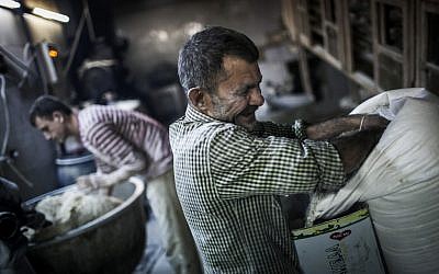 Men make bread at a bakery in the old city of Aleppo (photo credit: Andoni Lubaki/AP)