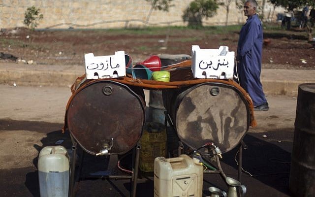 Fuel shortages in Syria have people buying diesel and gasoline at the side of a street in the village of Atmeh, near the Turkish border (photo credit: Khalil Hamra/AP)