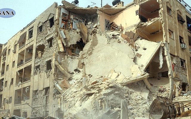 This photo released by the Syrian official news agency, SANA, shows damage caused to a building after a rocket slammed into it, killing at least 12 people, in Aleppo, Syria, Friday. (AP Photo/SANA) This photo released by the Syrian official news agency, SANA, shows damage caused to a building after a rocket slammed into it, killing at least 12 people, in Aleppo, Syria, Friday. (AP Photo/SANA)
