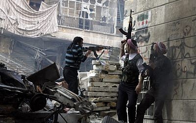 Free Syrian Army fighters fire at enemy positions during heavy clashes with government forces, in the Salaheddine district of Aleppo, Syria, Saturday, Dec. 29, 2012 (photo credit: AP/Abdullah Al-Yasin)