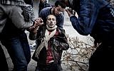 Men help a wounded civilian after a mortar attack in the Saif al-Dawlah neighborhood of Aleppo, Syria, Sunday, Jan. 13, 2013 (photo credit: Andoni Lubki/AP)
