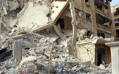 This photo released by the Syrian official news agency, SANA, shows damage after a rocket slammed into a building, killing at least 12 people, in Aleppo, Syria, Friday. (AP Photo/SANA) This photo released by the Syrian official news agency, SANA, shows damage after a rocket slammed into a building, killing at least 12 people, in Aleppo, Syria, Friday. (AP Photo/SANA)