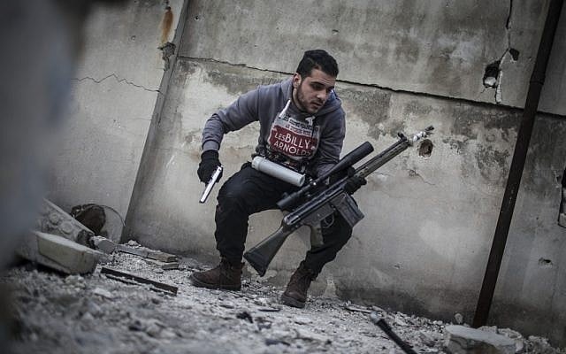 A sniper takes position on a roof during combat in the neighborhood of Saif Al-Dawlah in Aleppo, Syria. (photo credit: AP/Andoni Lubaki)