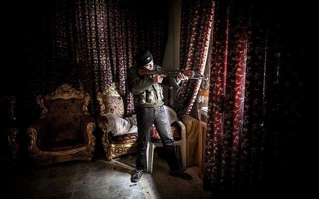 A Free Syrian Army fighter aims his weapon in the Saif al-Dawlah neighborhood of Aleppo, Syria, Sunday, Jan. 13, 2013 (photo credit: Andoni Lubaki/AP)