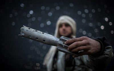 A Free Syrian Army fighter displays damaged ordnance in Aleppo, Syria, Tuesday, Jan. 15, 2013 (photo credit: Andoni Lubaki/AP)