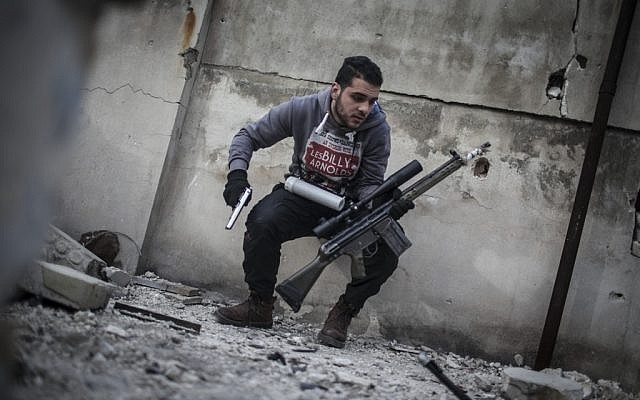 In this Friday, Jan. 18, 2013 photo, a sniper takes position on a roof during combat in the neighborhood of Saif Al-Dawlah in Aleppo, Syria (photo credit: AP/Andoni Lubaki) In this Friday, Jan. 18, 2013 photo, a sniper takes position on a roof during combat in the neighborhood of Saif Al-Dawlah in Aleppo, Syria (photo credit: AP/Andoni Lubaki)