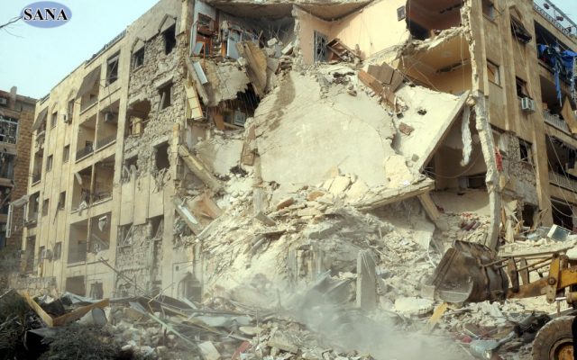 This photo released by the Syrian official news agency SANA, shows damage after a rocket slammed into a building, killing at least 12 people, in Aleppo, Syria, Friday, Jan. 18, 2013 (photo credit: AP/SANA) This photo released by the Syrian official news agency SANA, shows damage after a rocket slammed into a building, killing at least 12 people, in Aleppo, Syria, Friday, Jan. 18, 2013 (photo credit: AP/SANA)