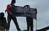 Syrian rebels from al-Qaeda affiliated Jabhat al-Nusra, wave their brigade flag as they step on the top of a Syrian air force helicopter, at Taftanaz air base that was captured by the rebels, in Idlib province, northern Syria, Friday January 11 2013 (photo credit: AP/Edlib News Network ENN)