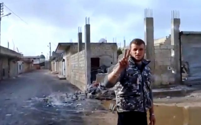 A Free Syrian Army soldier flashes the victory sign in Hama, Syria, January 2013 (photo credit: AP Photo/Ugarit News via AP video)