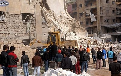 Rescue workers and bystanders surround a building damaged by a rocket attack, that killed at least 12 people, in Aleppo, Syria, on Friday (photo credit: AP/SANA)