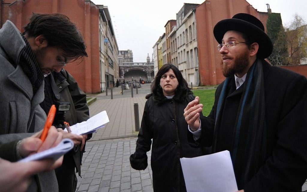 Moshe Friedman and his wife, Lea Rosenzweig, hold an improvised press conference outside Antwerp's Benoth Jerusalem, an all-female Haredi school forced by a Belgian judge to educate their sons. (Cnaan Liphshiz via JTA) Moshe Friedman and his wife, Lea Rosenzweig, hold an improvised press conference outside Antwerp's Benoth Jerusalem, an all-female Haredi school forced by a Belgian judge to educate their sons. (Cnaan Liphshiz via JTA)