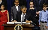 From left to right: Hinna Zeejah, 8, Taejah Goode, 10, Julia Stokes, 11, and Grant Fritz, 8, who wrote letters to President Barack Obama about the school shooting in Newtown, Conn., watch as Obama signs executive orders outlining proposals to reduce gun violence, Wednesday, Jan. 16, 2013, at the White House (photo credit: AP/Charles Dharapak)