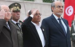 Tunisian Prime Minister Hamadi Jebali, right, President Moncef Marzouki, center, and head of constitutional assembly Mustapha Ben Jaafar, left, salute the national flag during a ceremony marking the second anniversary of the Revolution, Monday, January 14, 2013, in Tunis (photo credit: AP)