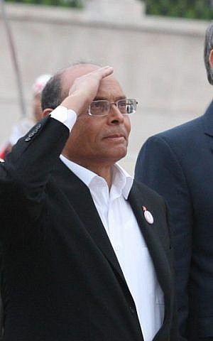 Tunisian Prime Minister Hamadi Jebali, right, President Moncef Marzouki, center, and head of constitutional assembly Mustapha Ben Jaafar, left, salute the national flag during a ceremony marking the second anniversary of the Revolution, Monday, January 14, 2013, in Tunis (photo credit: AP)