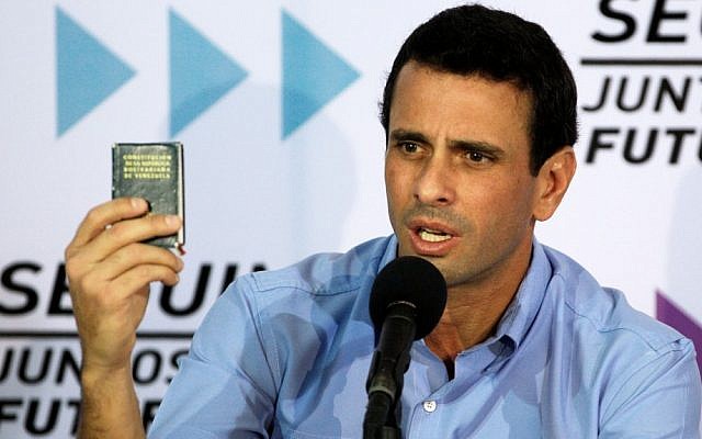Venezuela's opposition leader Henrique Capriles Radonski holds up a miniature copy of the national constitution during a news conference in Caracas, Venezuela in January, 2013 (photo credit: AP/Fernando Llano) Venezuela's opposition leader Henrique Capriles Radonski holds up a miniature copy of the national constitution during a news conference in Caracas, Venezuela in January, 2013 (photo credit: AP/Fernando Llano)