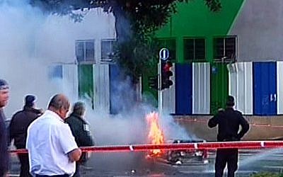 Smoke rises from a vehicle that was hit by an explosion in Tel Aviv, Thursday. Police estimate that the apparent bombing was aimed at an underworld figure who was riding in the car. (photo credit: Channel 2 screenshot)