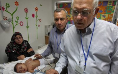 Paediatric cardiologists Dr. Akiva Tamir of Wolfson Medical Center and Dr. Omar Assali from Nablus's Rafidiya hospital examine a Palestinian child as part of Save a Child's Heart, an organization funded by the EU (photo credit: Flash90/David Silverman)
