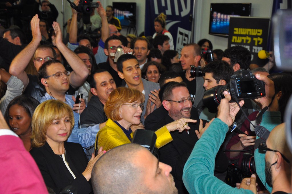 Ecstatic scenes at Yesh Atid's headquarters Tuesday night as the TV exit polls are broadcast, with putative MK Dov Lipman, bearded with kippa, at center (photo credit: Michal Shmulovich)