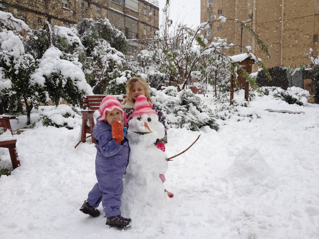 A girl hugging a snowman (photo credit: Mitch Ginsburg/Times of Israel staff) A girl hugging a snowman (photo credit: Mitch Ginsburg/Times of Israel staff)