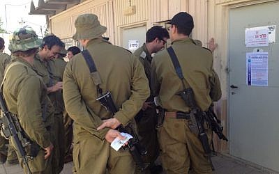 Reserve soldiers lining up to vote Tuesday at a base in central Israel. (photo credit: Times of Israel Staff)