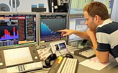 An analyst checks the numbers on the Tel Aviv Stock Exchange (Photo credit Meir Partush/Flash90)