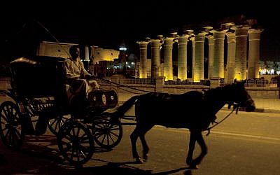 A horse-drawn carriage passing by the Luxor Temple on Tuesday. (photo credit: AP/Nasser Nasser)