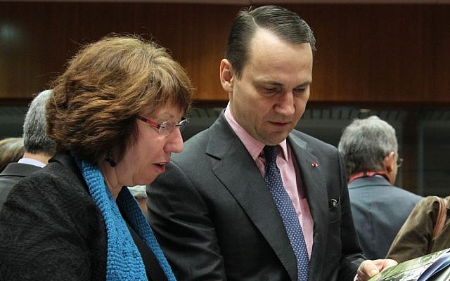 EU Foreign Policy Chief Catherine Ashton, left, looks at a book written by the wife of Poland's Foreign Minister Radoslaw Sikorski, during the EU foreign ministers' meeting, at the European Council building in Brussels, Monday, February 18, 2013 (photo credit: AP/Yves Logghe)