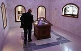 Bosnian conservationist technician Hamo Karkelja looks at original book of Sarajevo Haggadah, displayed at the National Museum of Bosnia and Herzegovina in Sarajevo, Bosnia, 2010 (photo credit: Amel Emric/AP)