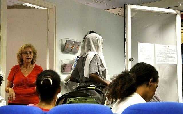 Asylum-seeking women (their faces purposely hidden to hide their identities) and a volunteer nurse at the Tel Aviv Refugee Clinic (photo credit: Michal Shmulovich/Times of Israel)