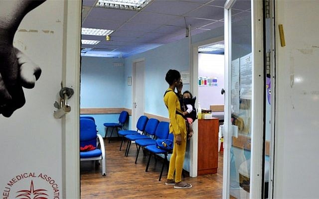 An asylum-seeking woman from Eritrea inquires about medical services for her and her child at the Tel Aviv Refugee Clinic (photo credit: Michal Shmulovich/Times of Israel)