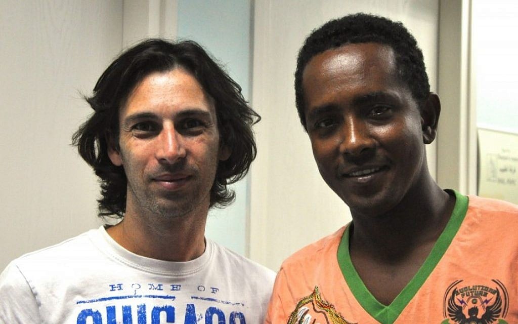 Orel Ben Ari, left, the head of the Tel Aviv Refugee Clinic (the Public Clinic), pictured with a young Eritrean man who had fled to Israel after sustaining several physical and emotional traumas in Egypt, including the loss of his hand, before being granted asylum in Europe. (photo credit: Michal Shmulovich/Times of Israel) Orel Ben Ari, left, the head of the Tel Aviv Refugee Clinic (the Public Clinic), pictured with a young Eritrean man who had fled to Israel after sustaining several physical and emotional traumas in Egypt, including the loss of his hand, before being granted asylum in Europe. (photo credit: Michal Shmulovich/Times of Israel)