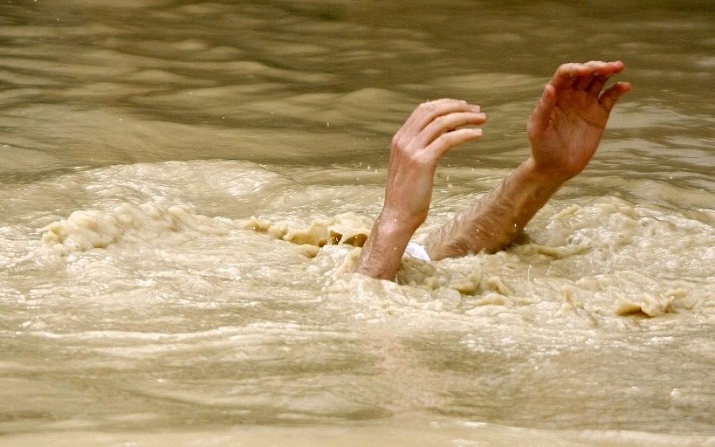 A Christian pilgrim submerged in the Jordan River during a ceremony at the baptismal site known as Qasr el-Yahud near Jericho. (Photo credit: Abir Sultan/Flash 90) A Christian pilgrim submerged in the Jordan River during a ceremony at the baptismal site known as Qasr el-Yahud near Jericho. (Photo credit: Abir Sultan/Flash 90)