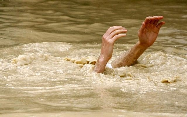 A Christian pilgrim submerged in the Jordan River during a ceremony at the baptismal site known as Qasr el-Yahud near Jericho. (Photo credit:  Abir Sultan/Flash 90)