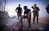 Want to join them? Maariv reports on a new donation program that allows tourists to visit IDF bases and eat with the soldiers. These soldiers prepare a meal while at an observation post by the Dead Sea in 2012 (photo credit: Moshe Shai/FLASH90)