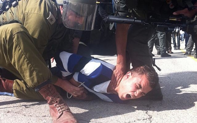 A soldier detains an Palestinian, Nov 2012 (photo credit: Roy Sharon/Flash90)