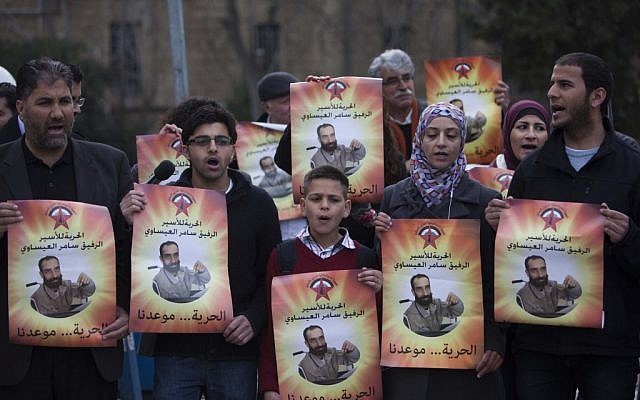 Palestinians holding pictures of Samer Issawi at a protest in Jerusalem on February 19. (photo credit: Yonatan Sindel/Flash90)