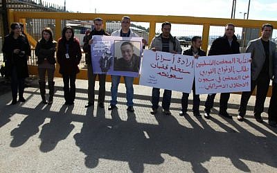 Palestinian journalists carry placards during a protest in support of jailed journalists and prisoners on hunger strike in Israeli prisons, in front of Ofer military prison, near the West Bank city of Ramallah, on Wednesday, February 20 (photo credit: Issam Rimawi/Flash90)