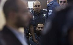 Israeli prison service guards surround Palestinian prisoner Samer Issawi, seated in his wheelchair, into a hearing at the Jerusalem Magistrate's Court on February 21, 2013. (photo credit: Yonatan Sindel/Flash90)