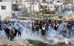 Palestinian protesters running away from tear gas shot by Israeli security forces during clashes next to Ofer prison, near Ramallah, on February 22, 2013. (photo credit: Issam Rimawi/Flash90)