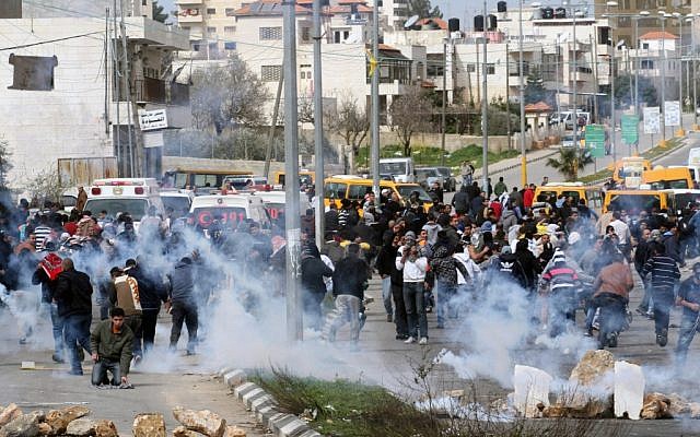 Palestinian protesters running away from tear gas shot by Israeli security forces during clashes next to Ofer prison, near Ramallah, on February 22, 2013. (photo credit: Issam Rimawi/Flash90) Palestinian protesters running away from tear gas shot by Israeli security forces during clashes next to Ofer prison, near Ramallah, on February 22, 2013. (photo credit: Issam Rimawi/Flash90)