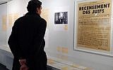 A man looks at a poster reading "Census of Jews" displayed in an exhibition at the Shoah Memorial in Paris, Tuesday, Feb. 12, 2013. The French state prepares to give back seven stolen Nazi-era paintings - 4 of which are in the Louvre - to two Jewish families, after a decade-long tug of war. (photo credit: AP/Jacques Brinon)
