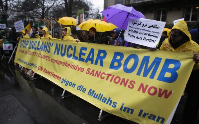 Demonstrators protest against Iranian Foreign Minister, Ali Akbar Salehi prior to his speech at the German Council Of Foreign Relations, a think tank for foreign policy, in Berlin, Germany, Monday, Feb. 4, 2013. The German phrase on the poster reads: 'Comprehensive and immediate UN-Sanctions against the Mullahs in iran.' (photo credit: AP/Markus Schreiber)