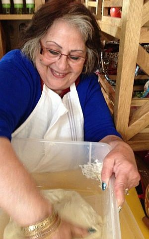 Marie Levy, Avi Levy's mother and teacher, kneading her daily dough at HaMotzi (photo credit: Jessica Steinberg/Times of Israel)
