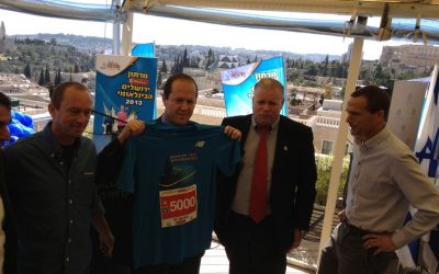 Mayor Nir Barkat holding up his New Balance Jerusalem Marathon 2013 running shirt (photo credit: Jessica Steinberg/Times of Israel)