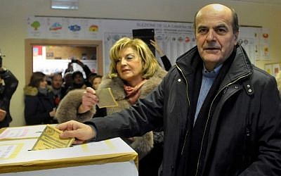 Pier Luigi Bersani, right, leader of the Democratic Party, casts his ballot with his wife Daniela, Sunday. (AP Photo/Marco Vasini)