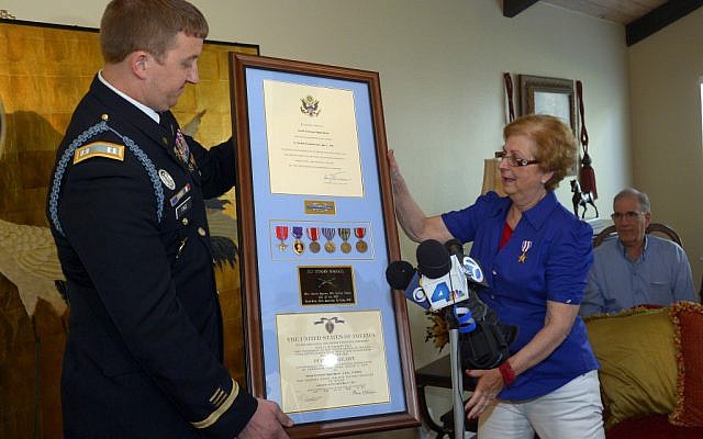 Army Capt. Zachariah L. Fike presents Hyla Merin with a plaque containing medals presented posthumously to her father after they were recently discovered in an apartment where Merin's mother and aunts had once lived. The ceremony took place at her home, Sunday, February 17, 2013. (photo credit: AP/Mark J. Terrill) Army Capt. Zachariah L. Fike presents Hyla Merin with a plaque containing medals presented posthumously to her father after they were recently discovered in an apartment where Merin's mother and aunts had once lived. The ceremony took place at her home, Sunday, February 17, 2013. (photo credit: AP/Mark J. Terrill)